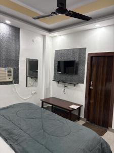 a bedroom with a bed and a flat screen tv at Hotel Shivaay Inn in Kānpur