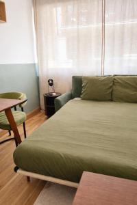 a bed in a room with a couch and a table at Studio plein centre in Aix-les-Bains