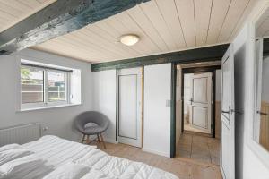 a bedroom with a bed and a window and a chair at 2001-Romo-Juvrevej-80 in Høm