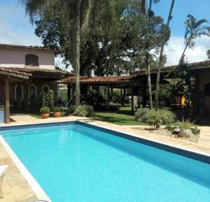 a swimming pool in front of a house at Pousada TURI in Caraguatatuba