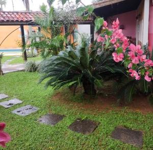 a garden with pink flowers and a house at Pousada TURI in Caraguatatuba