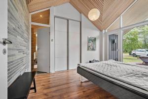 a bedroom with a bed and a large window at 0399-Romo-Strandskaden-22 in Høm