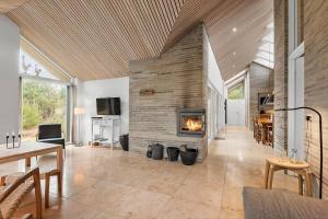 a living room with a fireplace and a dining room at 0399-Romo-Strandskaden-22 in Høm