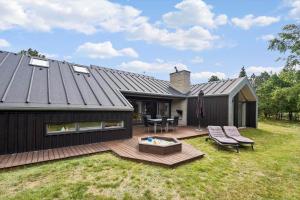 a house with a deck with a table and chairs at 0399-Romo-Strandskaden-22 in Høm