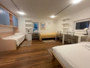 a room with two beds and a table and chairs at At the Burkulis' in Ljubljana