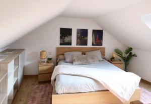 a bedroom with a white bed and pictures on the wall at Trésor de Beaurains in Beaurains