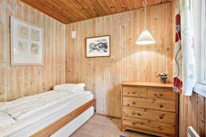 a bedroom with a bed and a wooden wall at 0028-Romo-Blabaervej-28 in Høm