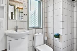 a white bathroom with a toilet and a sink at 0215-Romo-Vestergardsvej-8 in Høm +11 photos