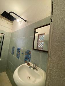 a bathroom with a sink and a mirror at Jardín del Mango Nu in Zipolite