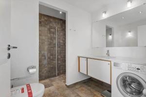 a bathroom with a washing machine and a sink at 1914-Romo-Blaklokkevej-914 in Høm +14 photos