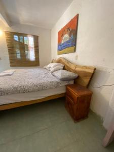 a small bedroom with a bed and a window at Jardín del Mango Nu in Zipolite