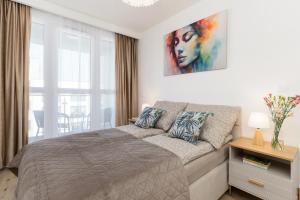 a bedroom with a bed and a painting on the wall at Apartament Sun&City in Bielsko-Biała