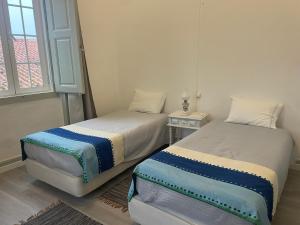 two twin beds in a room with a window at Casa Dona Joaquina in Reguengos de Monsaraz