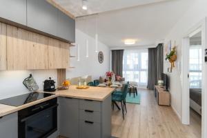a kitchen and living room with a table and chairs at Apartament Sun&City in Bielsko-Biała
