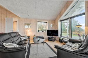 a living room with leather couches and a tv at 0180-Romo-Ejnar-Mikkelsensvej-8 in Høm