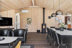 a dining room with a table and leather chairs at 0120-Romo-Smafolksvej-61 in Høm