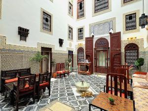 a courtyard with chairs and a fountain in a building at Riad Dar Mazaj Fes in Fez