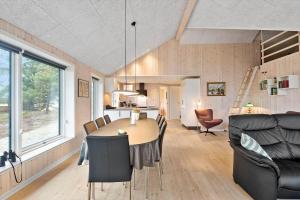 a dining room and living room with a table and chairs at 0180-Romo-Ejnar-Mikkelsensvej-8 in Høm
