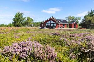a red house in a field with purple flowers at 0180-Romo-Ejnar-Mikkelsensvej-8 in Høm