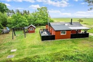 a red house with a playground and a swing at 0264-Romo-Lyngvejen-37 in Høm