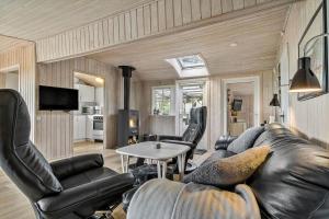 a living room with a leather couch and chairs at 0264-Romo-Lyngvejen-37 in Høm