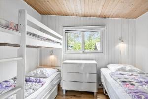 a bedroom with two bunk beds and a window at 0264-Romo-Lyngvejen-37 in Høm