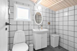 a bathroom with a toilet and a sink and a mirror at 0264-Romo-Lyngvejen-37 in Høm +15 photos
