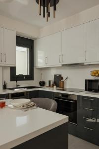 a kitchen with black and white cabinets and a sink at Estia Urban Stay in Ioannina +10 photos