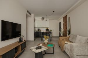 a living room with a couch and a tv at Estia Urban Stay in Ioannina