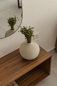 a vase sitting on a table in front of a mirror at Estia Urban Stay in Ioannina