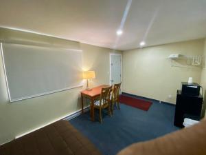 a room with a table with chairs and a lamp at Kings Inn Orillia in Orillia