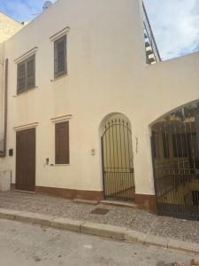 a white building with two gates on a street at Casa indipendente favignana in Favignana