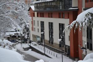a snow covered street in front of a building at Apartamentos Gorbea Suites in Sierra Nevada