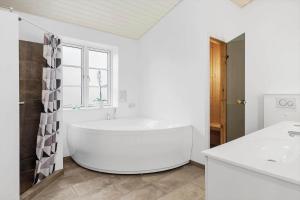 a white bathroom with a tub and a sink at 0003-Romo-Vestervej-39 in Høm +21 photos