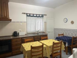 a kitchen with a table and a sink and a window at Casa Dona Joaquina in Reguengos de Monsaraz