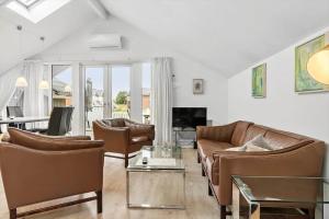 a living room with leather couches and a table at 0281-Romo-Vestergade-3-Ap-13 in Høm