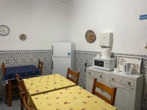 a kitchen with a table and a microwave and a refrigerator at Casa Dona Joaquina in Reguengos de Monsaraz +9 photos