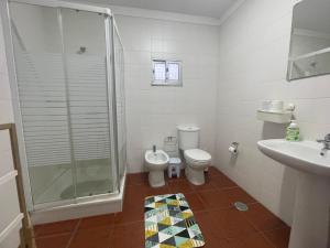 a bathroom with a shower and a toilet and a sink at Casa Dona Joaquina in Reguengos de Monsaraz