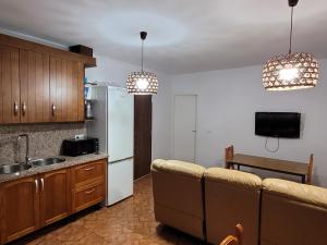 a kitchen with a white refrigerator and a couch at Alojamiento GUADALENTIN in Pozo Alcón