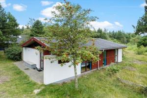 a small house with a tree in front of it at 0418-Romo-Sonderstrandvej-19 in Høm