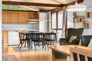 a kitchen and living room with a table and chairs at 0418-Romo-Sonderstrandvej-19 in Høm