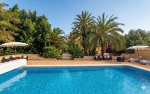 a swimming pool with trees and palm trees at Open Sky Villa in Denia