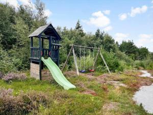 a playground with a slide and swings in a field at 0418-Romo-Sonderstrandvej-19 in Høm