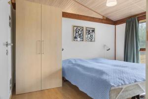 a bedroom with a blue bed and a cabinet at 0418-Romo-Sonderstrandvej-19 in Høm