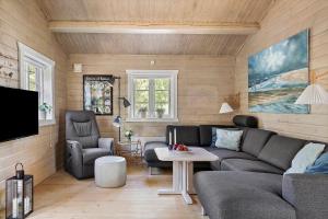 a living room with a couch and chairs and a tv at 0311-Romo-Strandskaden-10 in Høm