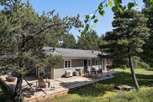 a house with a wooden deck in the yard at 0311-Romo-Strandskaden-10 in Høm