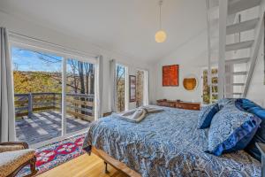 a bedroom with a bed and a large window at Serendipity -- Hot Tub - Pet Friendly - Fire Pit - Grill - Porch - Deck - Wifi - Pool Access - Games in Berkeley Springs