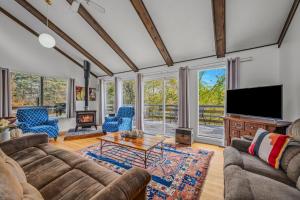 a living room with a couch and a tv at Serendipity -- Hot Tub - Pet Friendly - Fire Pit - Grill - Porch - Deck - Wifi - Pool Access - Games in Berkeley Springs