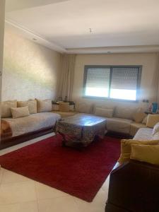 a living room with couches and a red rug at Résidence sable d or in Mansouria
