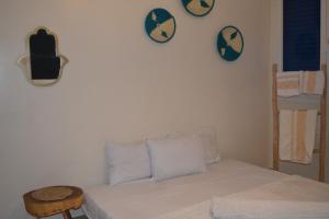 a bedroom with a bed and two clocks on the wall at west wave surf house in Tamraght Ouzdar